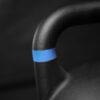 Detalle de la textura y banda de color azul en el asa de la kettlebell Ironcast.