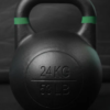 Kettlebell de competición Ironcast de 24 kg negra con banda verde para levantamientos pesados.